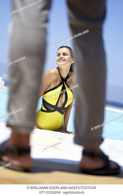 view of woman at pool between legs of man, bikini, sexy, flirting, summer, holiday, dating, summer fling