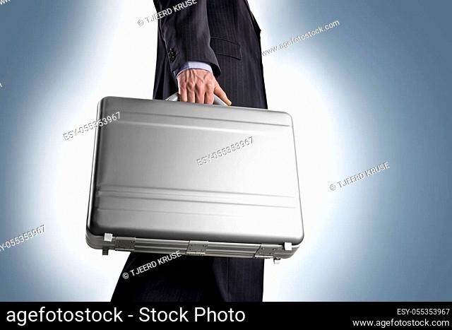 Businessman with a metal suitcase a light blue background