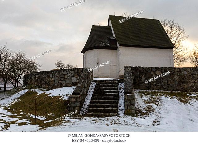 Small Gothic church near a cemetary in a village of Turiec Region in northern Slovakia in winter.