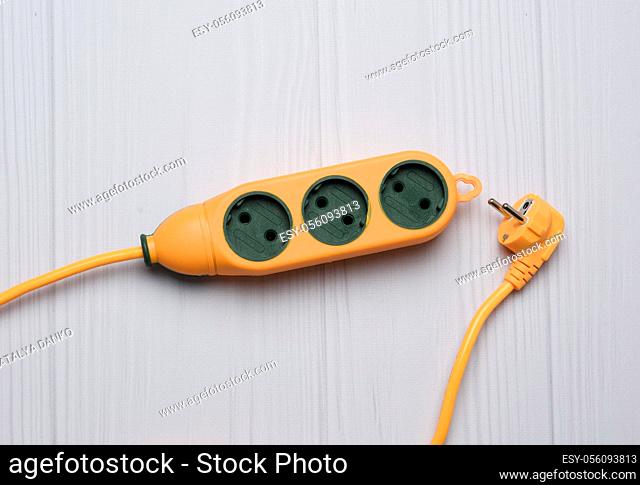rubber orange power strip with three sockets on a white background, top view