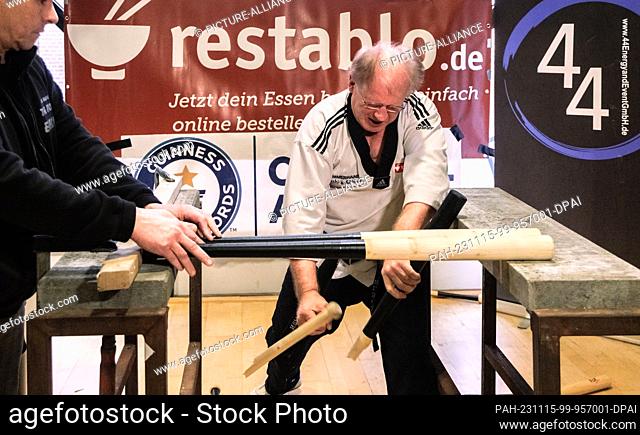 15 November 2023, Hamburg: Martial artist Muhamed Kahrimanovic in his Guinness record attempt ""Most baseball bats smashed in one minute while holding a raw...