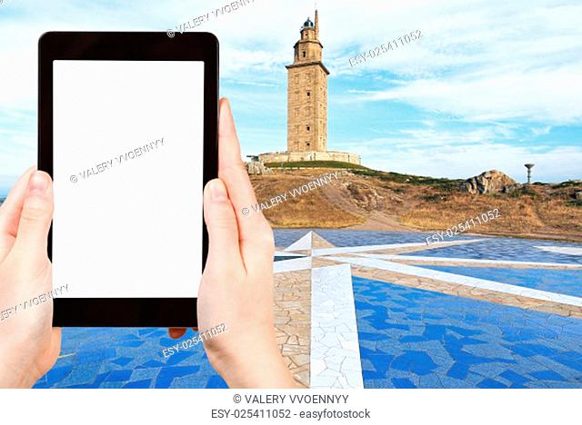 travel concept - tourist photograph ancient roman monument - lighthouse Tower of Hercules, La Coruna, Galicia, Spain on tablet pc with cut out screen with blank...