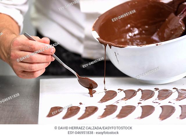 Professional confectioner making chocolate sweets at confectionery shop