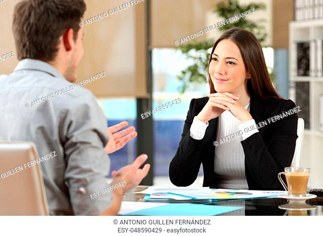 Businesswoman attending listening to a client who is talking at office