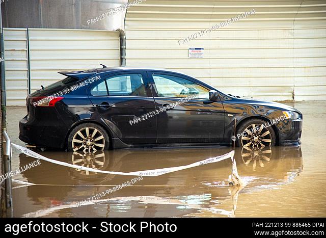13 December 2022, Portugal, Lissabon: A car stands on a flooded street. Heavy rains have caused damage to roads, houses and stores in the Portuguese capital