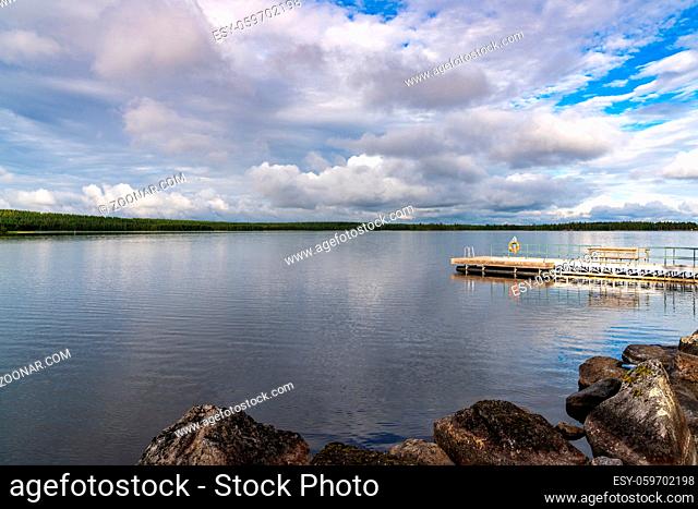 A wooden floating dock and swimming platform on the shores of a calm and peaceful lake