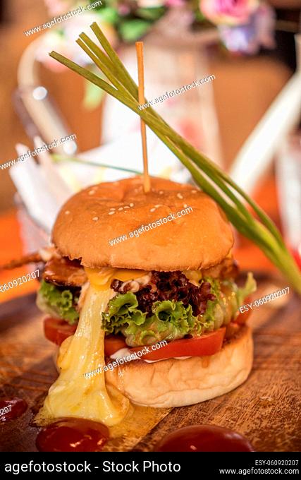 Closeup of beautifully served fresh home made burger isolated on wooden cutting board