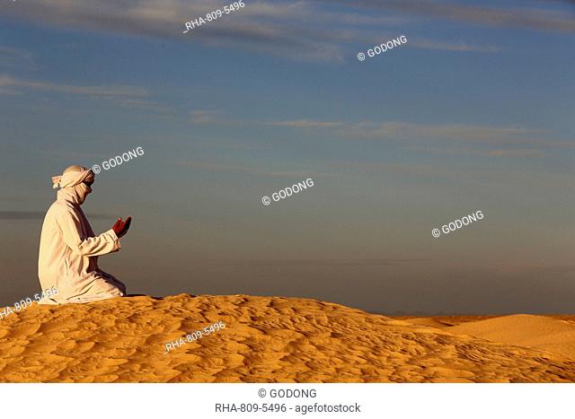 Bedouin praying in the Sahara, Douz, Kebili, Tunisia, North Africa, Africa