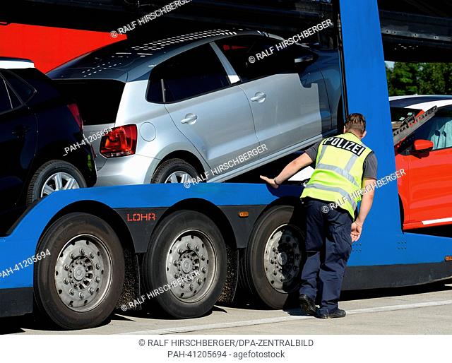 A police officer searches a truck at the A2 motorway near Brandenburg, Germany, 22 July 2013. The police headquarters West has ordered several traffic controls...