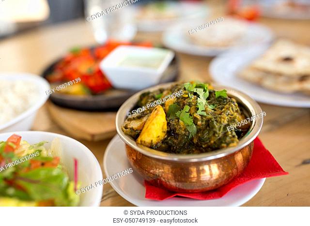 close up of aloo palak dish in bowl on table