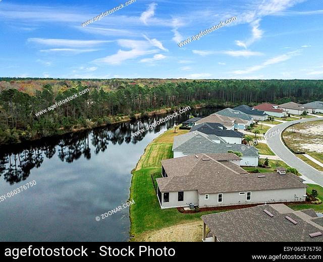 Houes and Screen Porches Line the Bank of a Small Pond in an American Neighborhood from Above