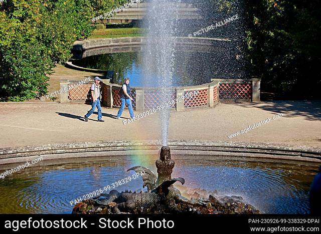 26 September 2023, Saxony-Anhalt, Blankenburg: A water feature creates a small rainbow in the sunlight in the park of Ballenstedt Castle