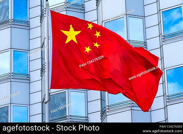 24.07.2020, Berlin, the waving red national flag of the People's Republic of China with the five yellow stars on a red background in sunshine in front of the...