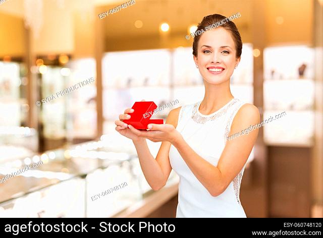 smiling woman with red gift box at jewelry store