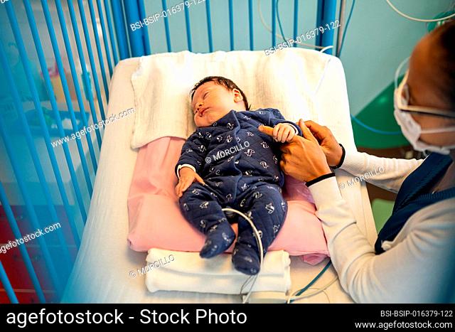 Mother and son with bronchiolitis with a nursery nurse in a hospital pediatric ward