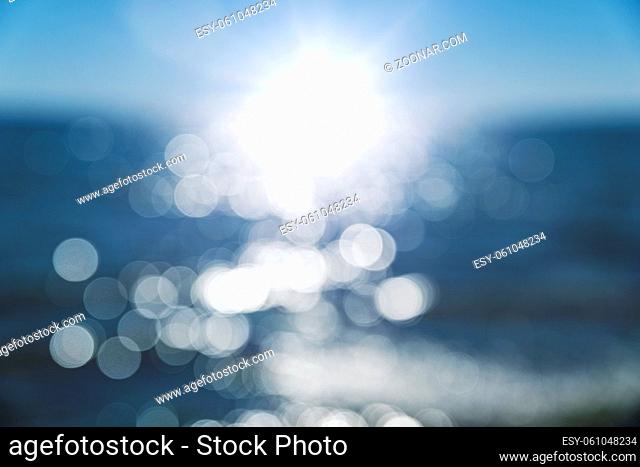 abstract blurred background with a view of the sea and a bright sun and rays, a view to the distance
