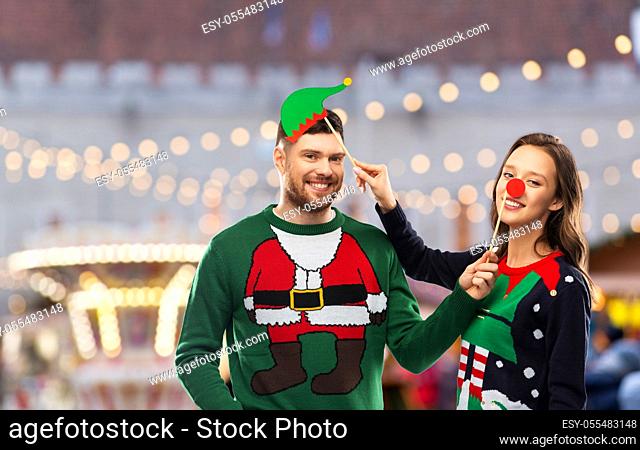 couple in sweaters with christmas party props