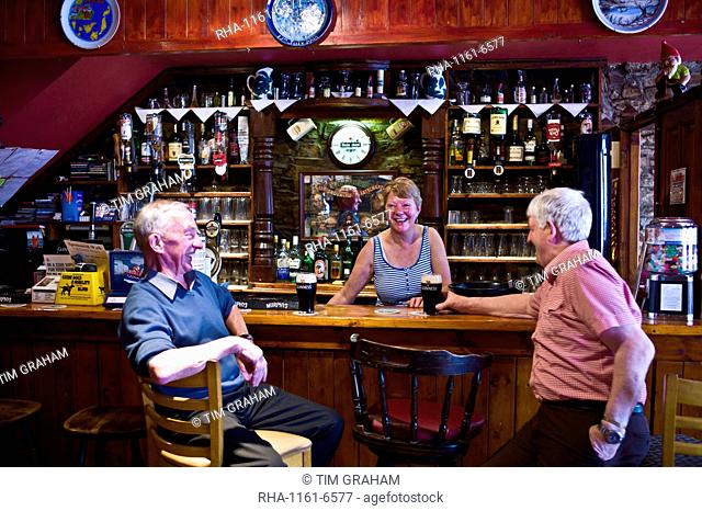 Grainne laughing with locals at her traditional Irish bar, Grainne's, in Mill Street, Timoleague, West Cork, Ireland