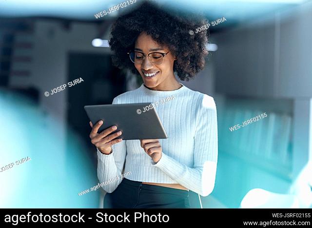 Smiling businesswoman using tablet PC at office