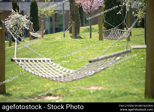 PRODUCTION - 28 April 2021, Hessen, Fulda: Empty hammock hanging on the campus of Fulda University of Applied Sciences. Sitting alone in the children's room in...