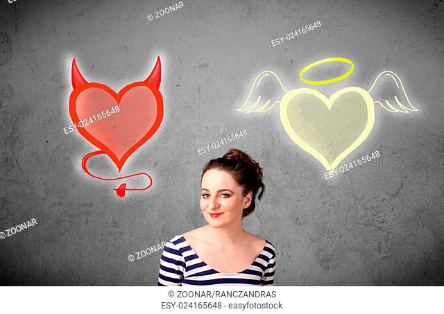 Woman standing between the angel and devil hearts