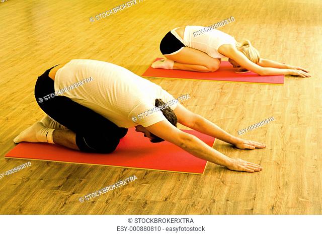 Image of man and woman doing physical exercises on mats in the sports club together