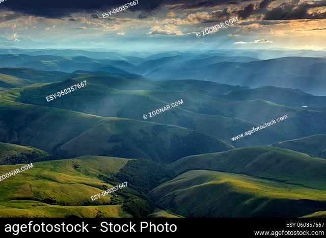 Beautiful landscape of the sunbeams on hills in Caucasus mountains at sunset, Russia