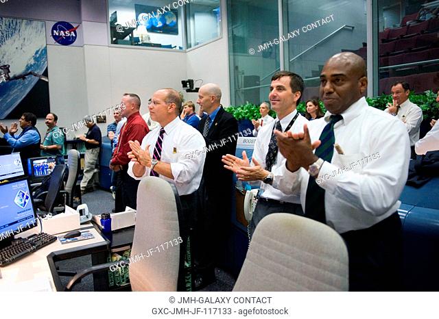 In the space shuttle flight control room of the Mission Control Center at NASA's Johnson Space Center, NASA managers applaud the successful end to the Space...