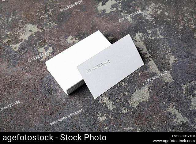 Photo of blank business cards on concrete background. Mock-up for branding identity. Studio shot
