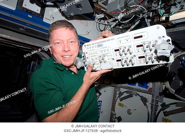 NASA astronaut Mike Fossum, Expedition 28 flight engineer, replaces a failed electronic unit for the Minus Eighty Laboratory Freezer for ISS 3 (MELFI-3) with a...