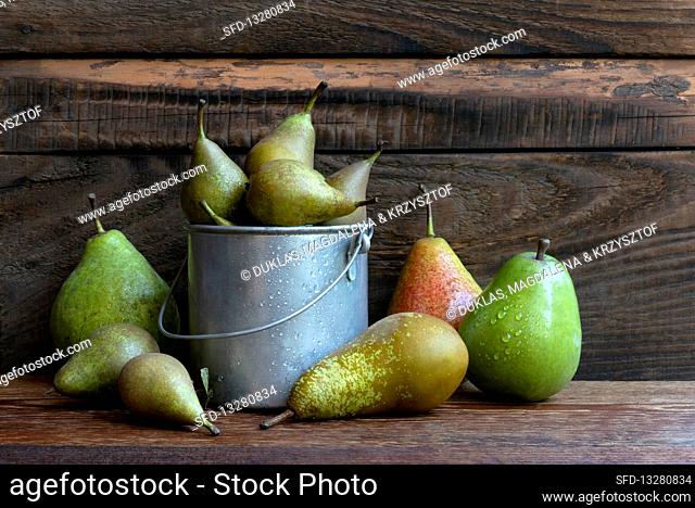 A composition of different kinds of pears on a wooden table in the garden