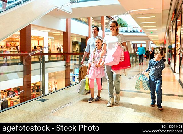 Glückliche Familie beim Shopping mit vielen Einkaufstüten im Einkaufszentrum