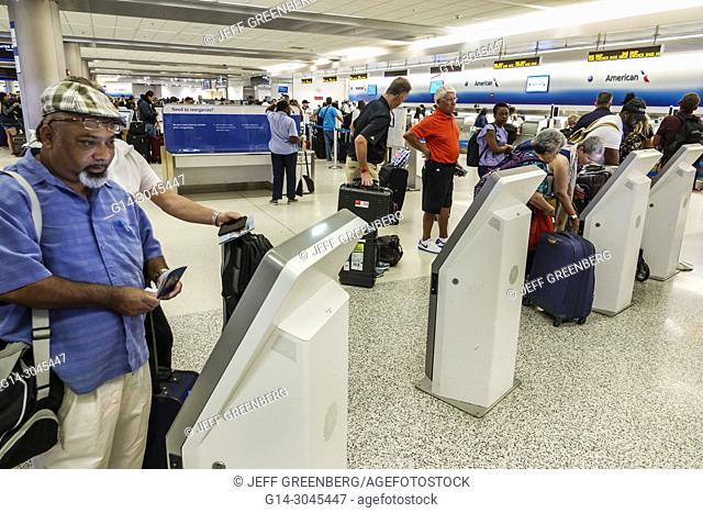 Florida, Miami, Miami International Airport MIA, terminal, American Airlines, self check-in kiosk, Black, man, passenger, luggage