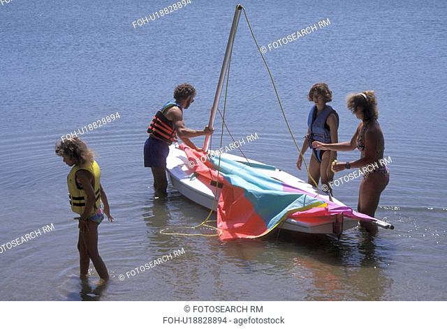 family, sailing, MN, Minnesota, Alexandria, Family rigging a sunfish with their 8 and 13 year old daughters to go sailing on Maple Lake in Alexandria in the...