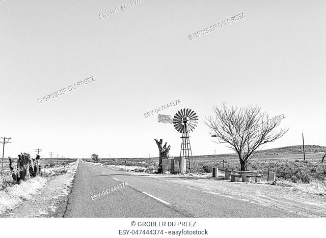 Monochrome view of a water-pumping windmill and picnic spot on road R48 between Phillipstown and De Aar in the Northern Cape Province