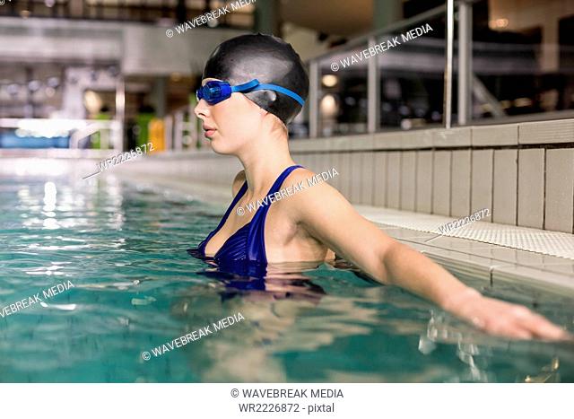 Attractive woman with cap and goggles in the pool