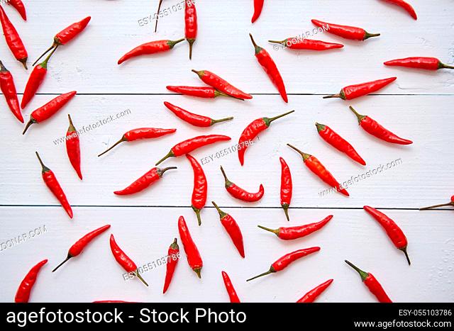 Red hot little chili peppers pattern isolated on white wooden table background. Top view. Flat lay