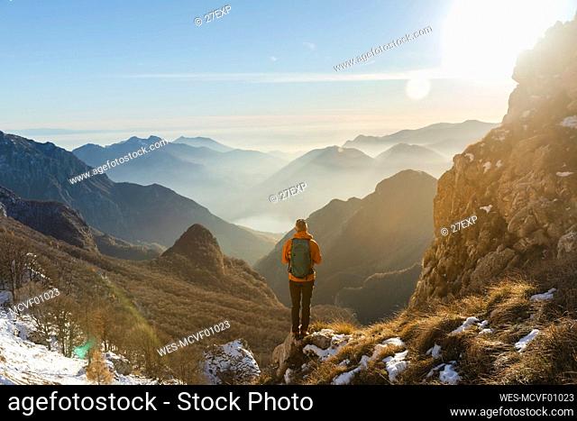 Hiker with backpack standing on mountain