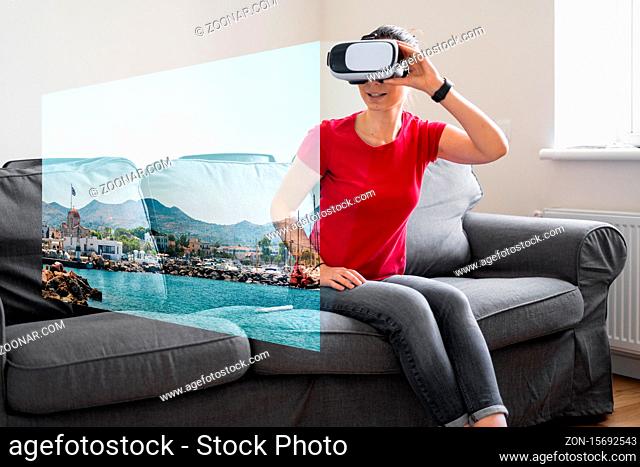 Woman with VR glasses sitting on the sofa at home and watching online travel photo. VR booking, getting experiences. Quarantine home activity