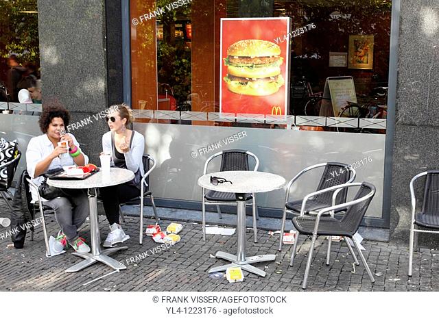 Girls eating hamburgers on a terrace, streetscene, Utrecht, Netherlands