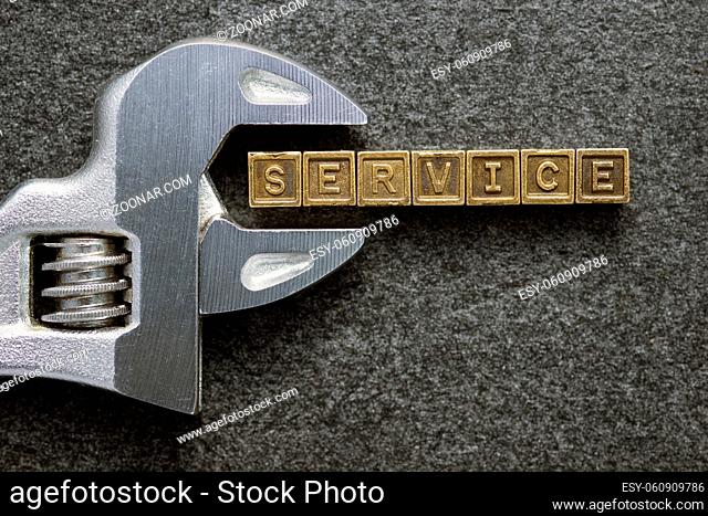 service word made from metallic blocks with adjustable wrench