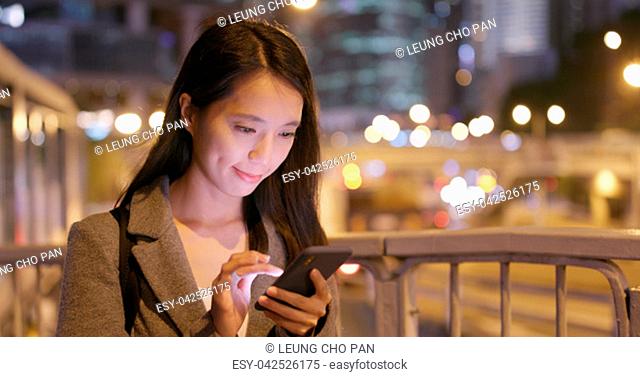 Business woman read on smart phone with traffic background at night