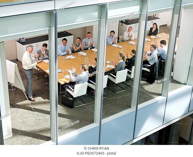 Business people clapping in meeting in conference room