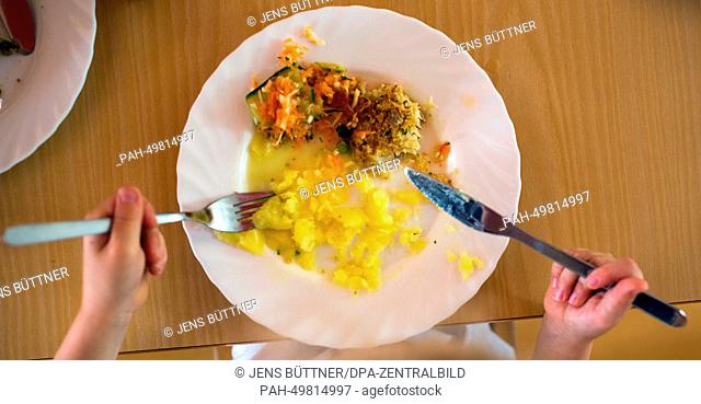 Nursery child Lilly eats her lunch from her plate with a knife and fork at the integrated nursery 'Plappersnut' in Wismar, Germany, 19 June 2014