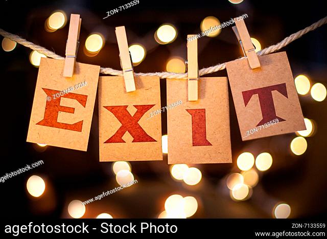 The word exit printed on clothespin clipped cards in front of defocused glowing lights