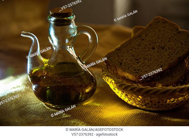 Still life: oil bottle and bread in a basket. Close view