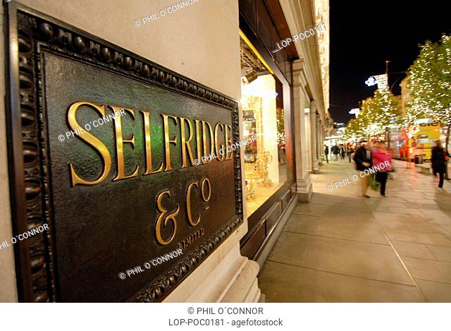 Detail of Selfridges sign at night. The development of Oxford Street as a prime shopping area began at the start of 20th century with the opening of the major...