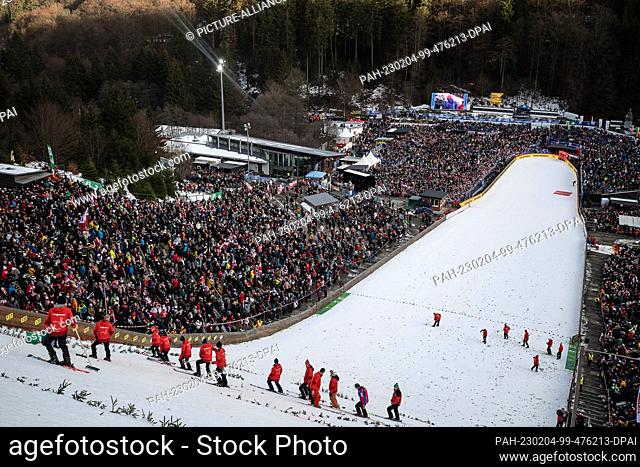 04 February 2023, Hesse, Willingen: Nordic skiing, ski jumping: World Cup, large hill, men. Helpers prepare the slope. Photo: Swen Pförtner/dpa