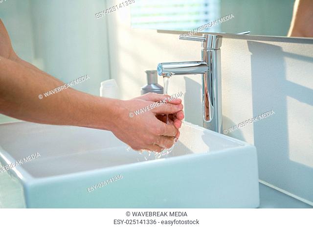 Man washing his hands in bathroom sink