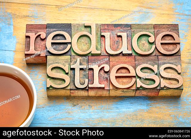 reduce stress - word abstract in letterpress wood type with a cup of tea
